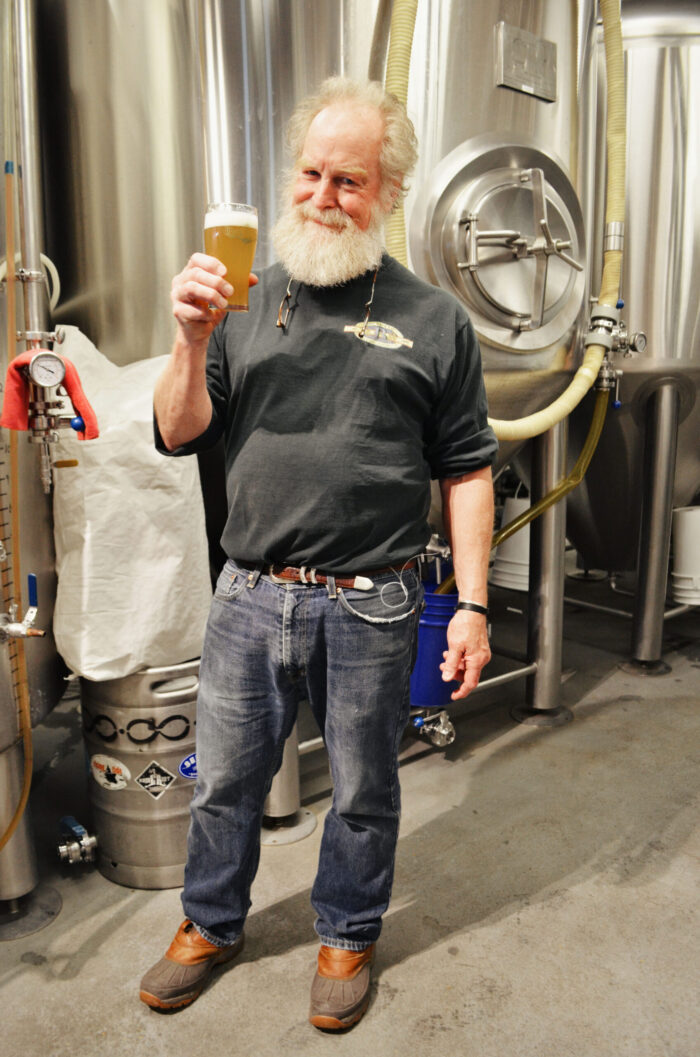 Tod Mott of Tributary Brewing holding a Liquid Riot beer